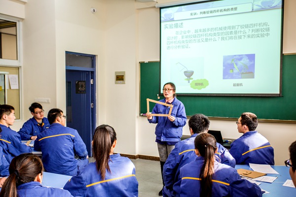 伍思思老师指导学生自制铰链四杆机构模型，固定不同杆件，通过实验进一步理解铰链四杆机构的性质及在机械设备中的应用。